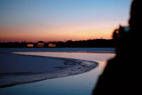 A frozen lake beneath a pink and blue sunset