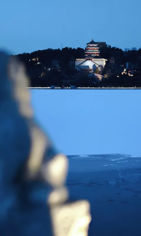 A distant pavilion across a frozen lake