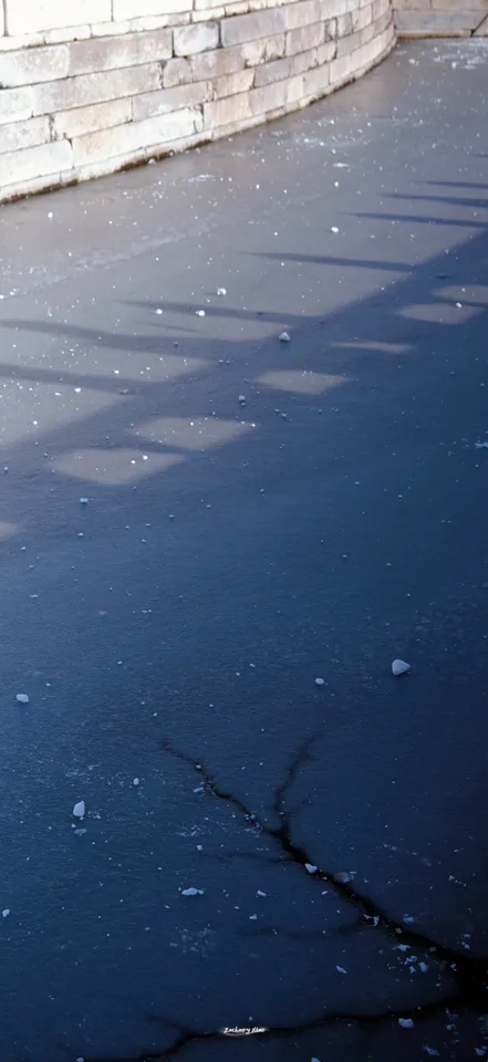 Shadows across a frozen waterway
