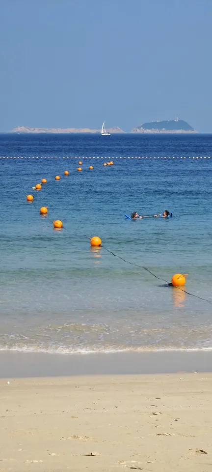 Swimmers and buoys in a turquoise bay