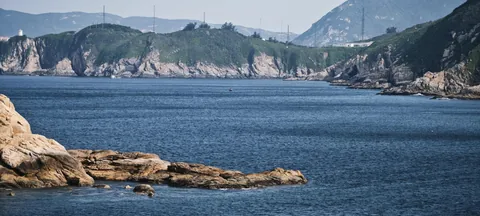 A rocky coast and distant mountains