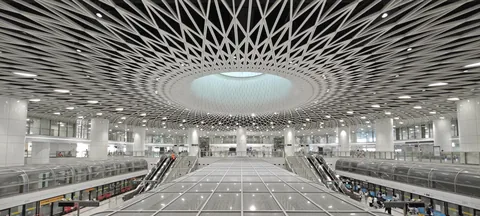A circular lattice ceiling above a station concourse