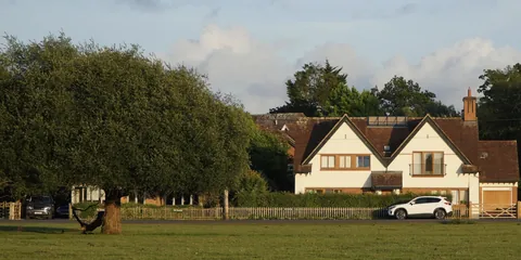 A house beside a tree-lined road