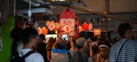 A crowd gathered around glowing lanterns