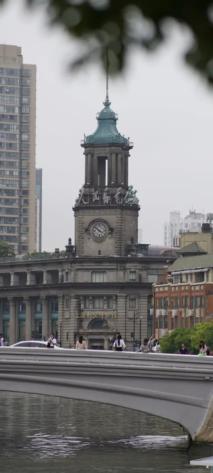 A clock tower framed by leaves