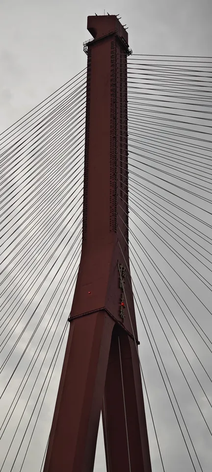 A red bridge pylon against the sky