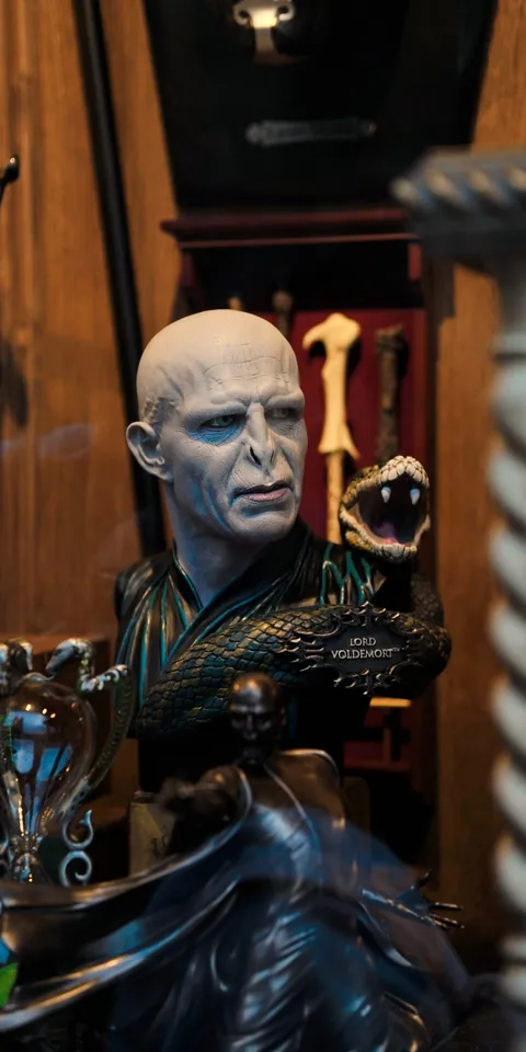 A pale costumed figure in a dark doorway