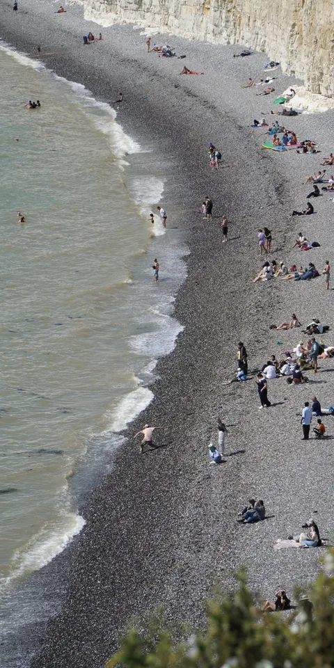 A curving shoreline below white cliffs