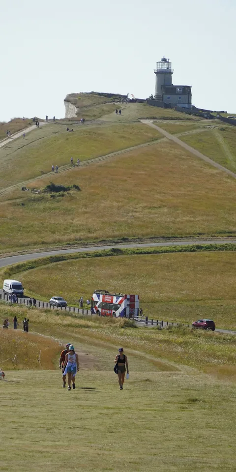 A winding path toward a hilltop lighthouse