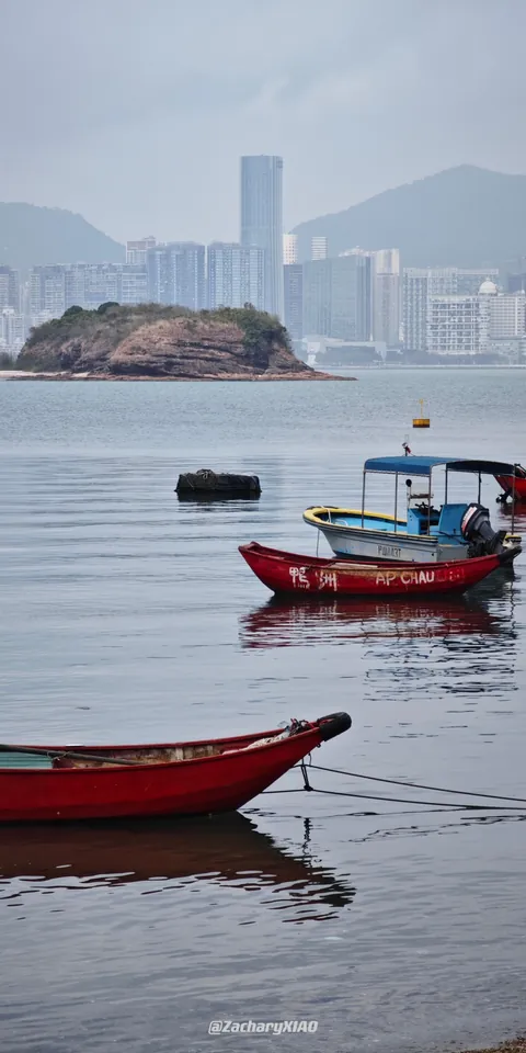 Red boats with a distant city skyline