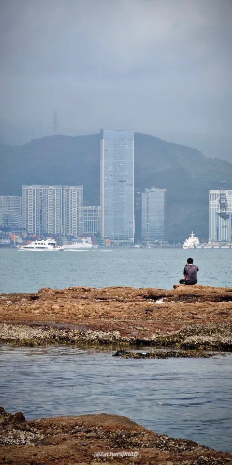 A waterfront and hazy city towers